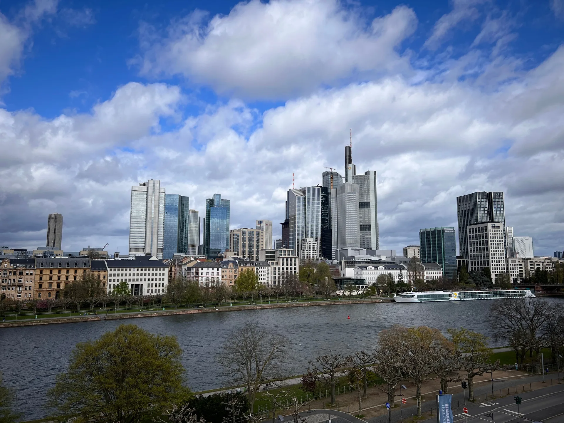 The Frankfurt skyline over the Main, a boat moored on the far bank.